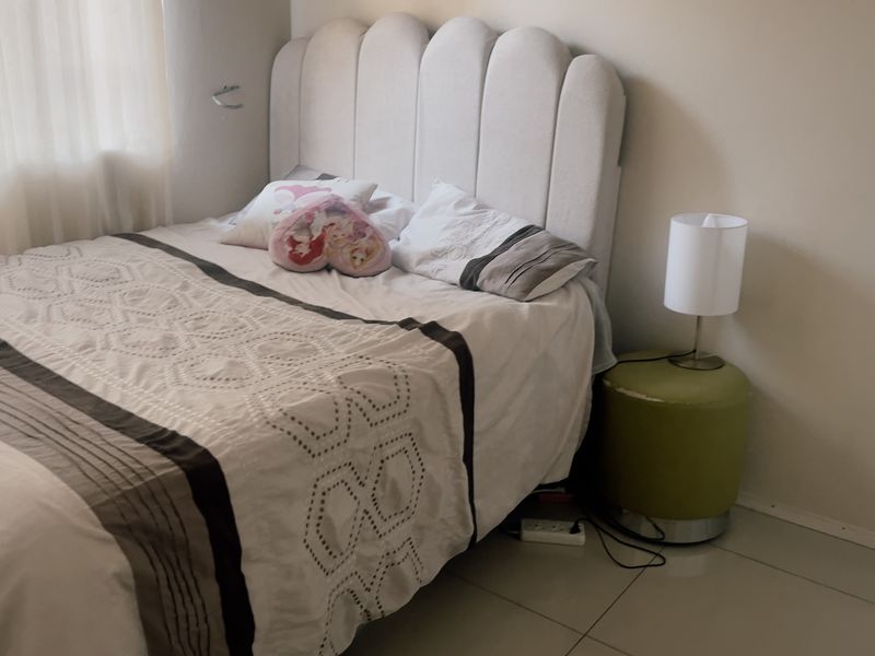 A bedroom featuring neutral wall finishes and tiled flooring, providing a functional and comfortable sleeping space.