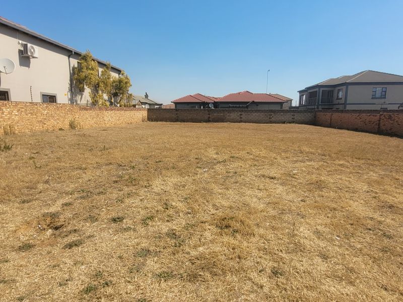 A vacant residential plot of land enclosed by brick boundary walls, offering a clear space for future development.
