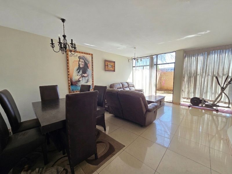Spacious open-plan living and dining area featuring large glass sliding doors that provide natural light and access to the outdoor space.