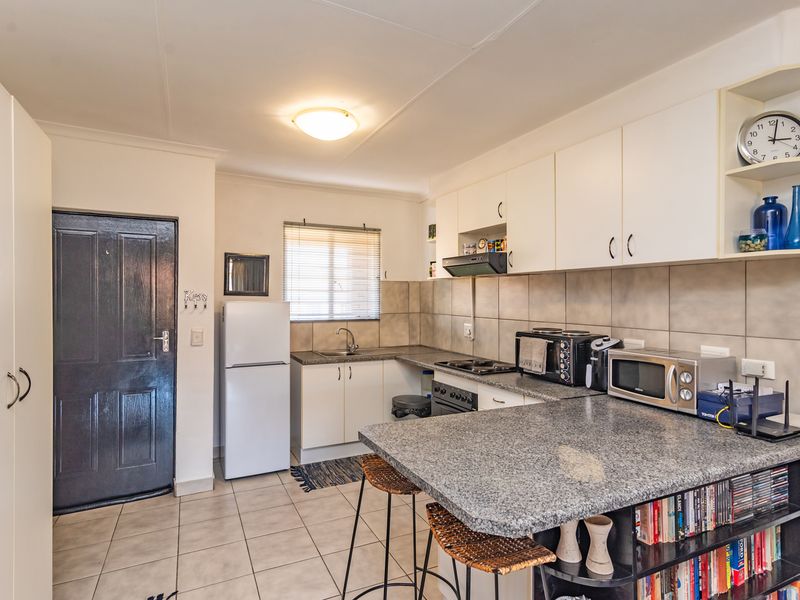 Functional kitchen featuring granite countertops, ample built-in cabinetry, tiled backsplash, and integrated cooking appliances, providing a practical workspace for daily meal preparation.