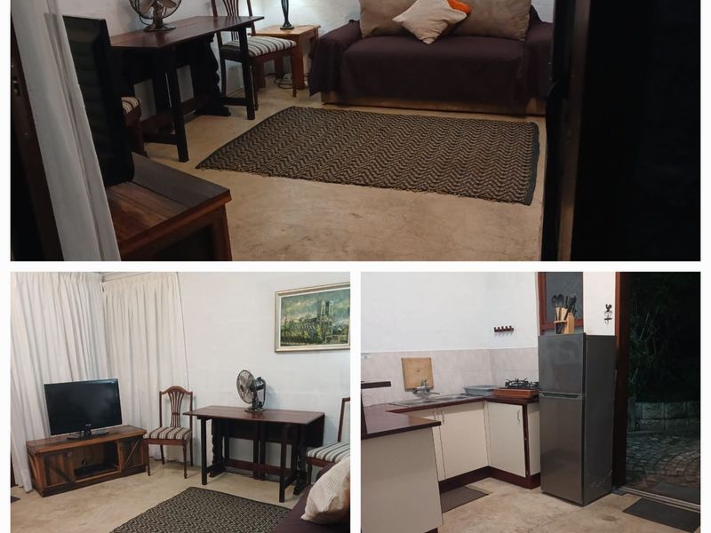 Open plan living area and kitchen featuring concrete flooring and basic cabinetry, suitable for a compact cottage layout.