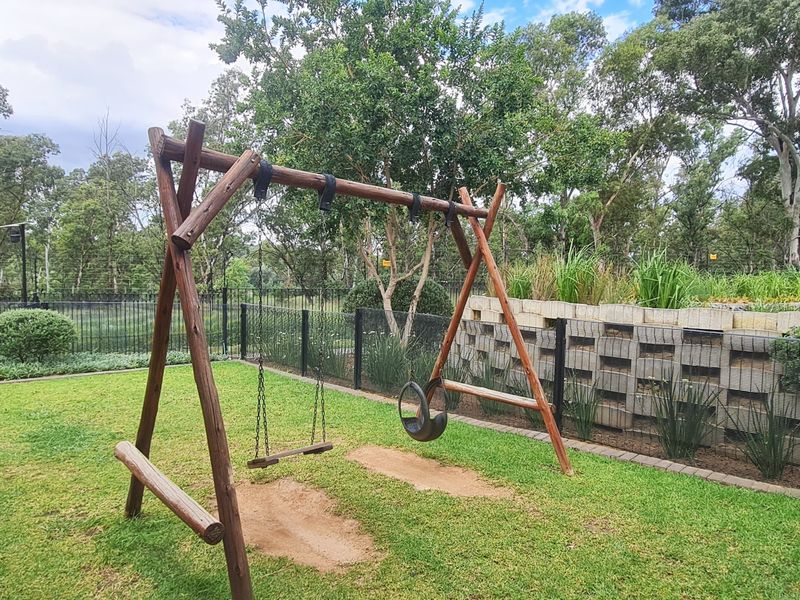 A well-maintained private garden featuring a lawn, retaining wall, and secure perimeter fencing, providing a pleasant outdoor space.