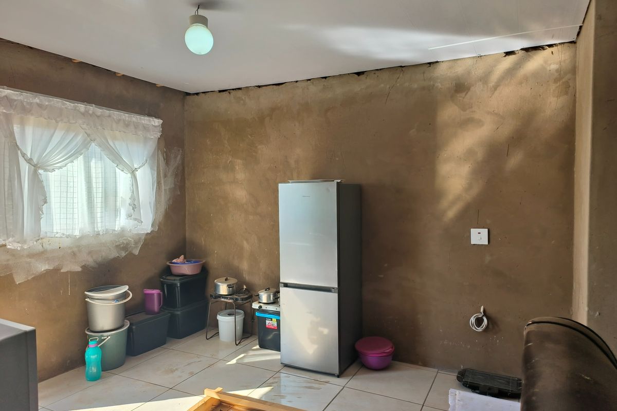 An unfinished kitchen space featuring tiled flooring and basic electrical infrastructure, requiring significant renovation and cabinetry installation to become a functional culinary area.