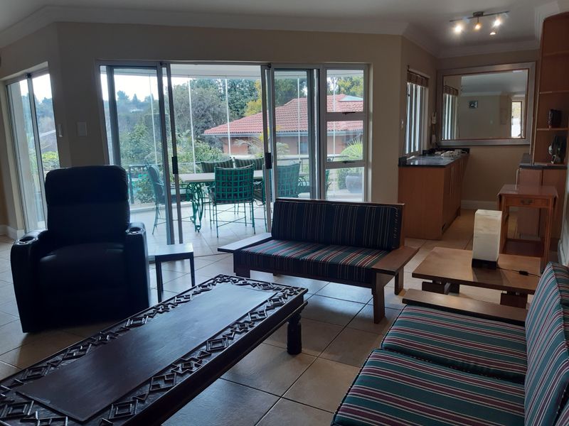 Spacious open-plan living area featuring tiled floors, built-in cabinetry, and large sliding glass doors providing access to an outdoor patio.