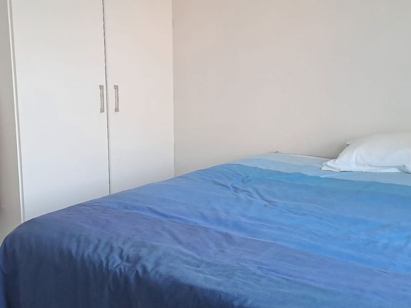A simple bedroom featuring a built-in wardrobe and neutral wall finishes.