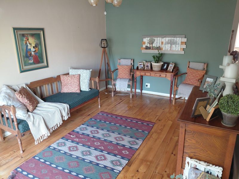 A living room featuring polished timber flooring and a dual-tone wall finish, providing a warm and traditional atmosphere.