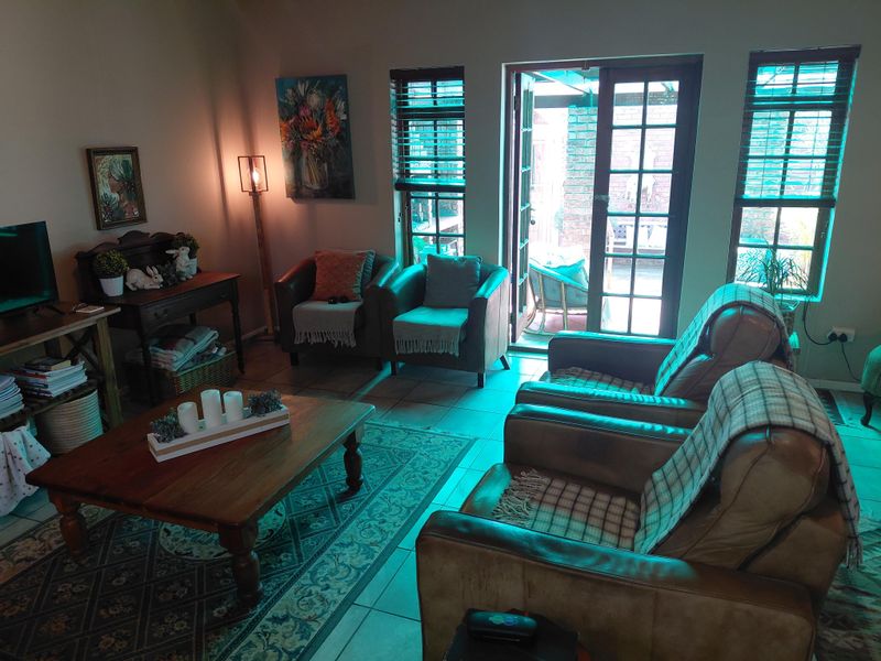 A cozy living room featuring tiled flooring and french doors that provide direct access to an outdoor patio area.