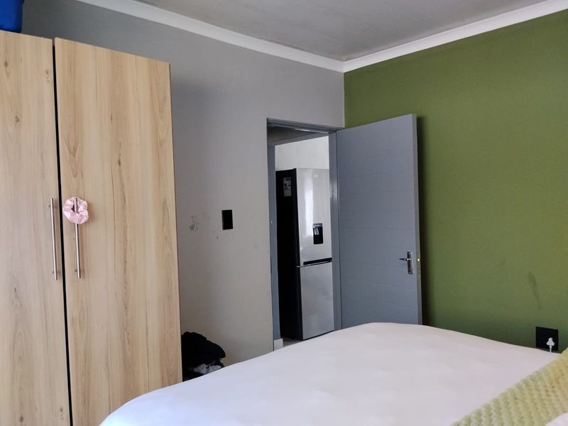 A bedroom featuring a built-in wardrobe, coving, and a doorway leading to an adjacent space.
