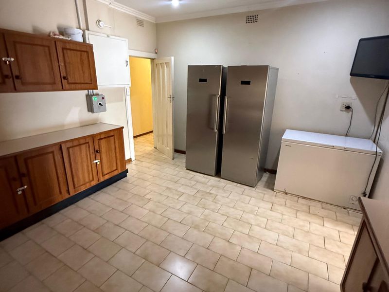 A functional laundry or utility room featuring built-in wooden cabinetry, tiled flooring, and recessed ceiling lighting.