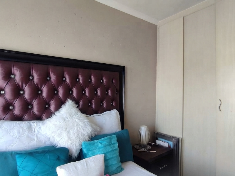 A bedroom featuring a built-in wardrobe with light-toned doors and neutral wall finishes.