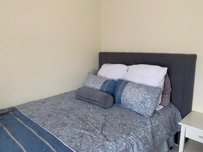 A simple bedroom space featuring neutral wall finishes, suitable for a comfortable sleeping area.
