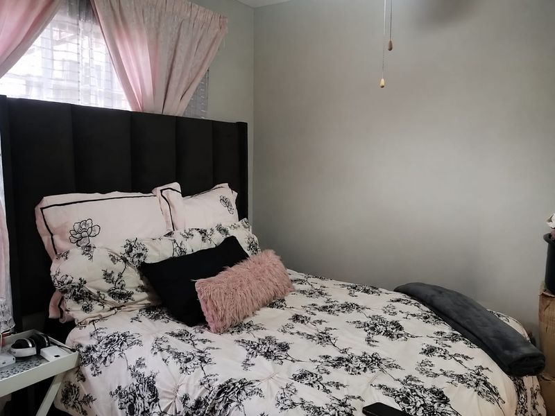 A cozy bedroom featuring a ceiling fan and neutral wall finishes, providing a comfortable and functional sleeping space.