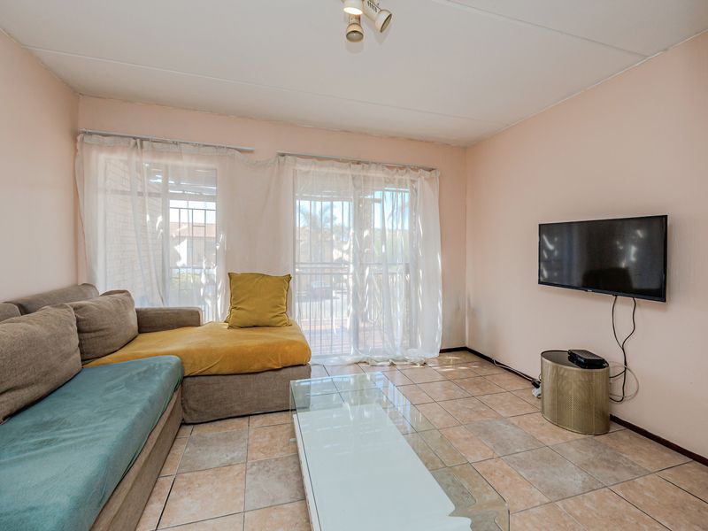 A living room featuring tiled flooring and sliding glass doors that provide access to an outdoor area.