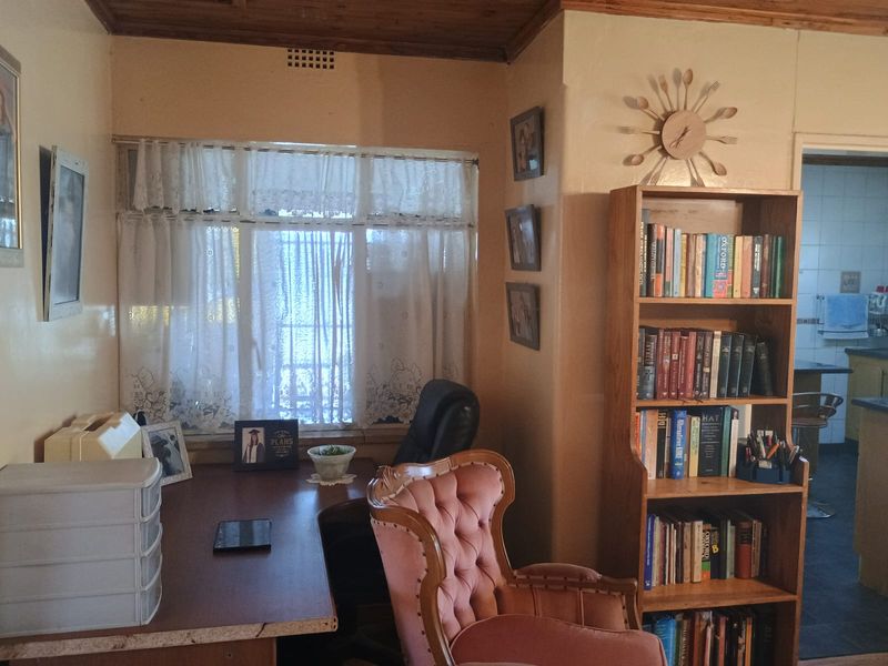 A home office space featuring a built-in desk and a wooden ceiling, providing a functional workspace within the property.