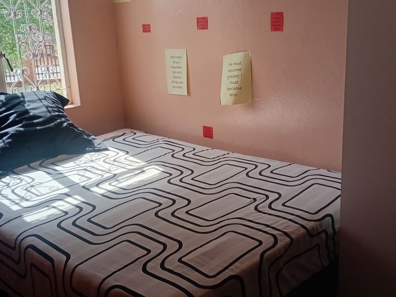 A bedroom featuring a window with a decorative security gate, finished with painted walls.
