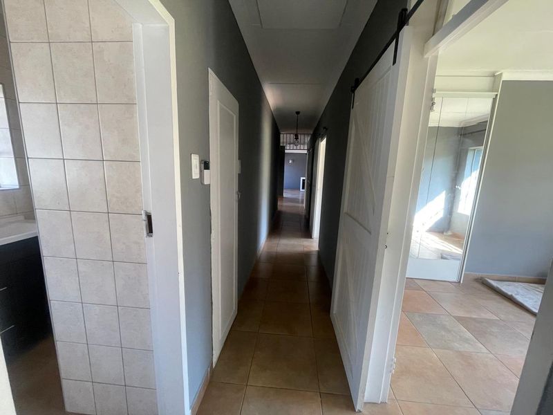 A functional hallway featuring tiled flooring and a sliding barn door, providing access to adjacent rooms within the home.