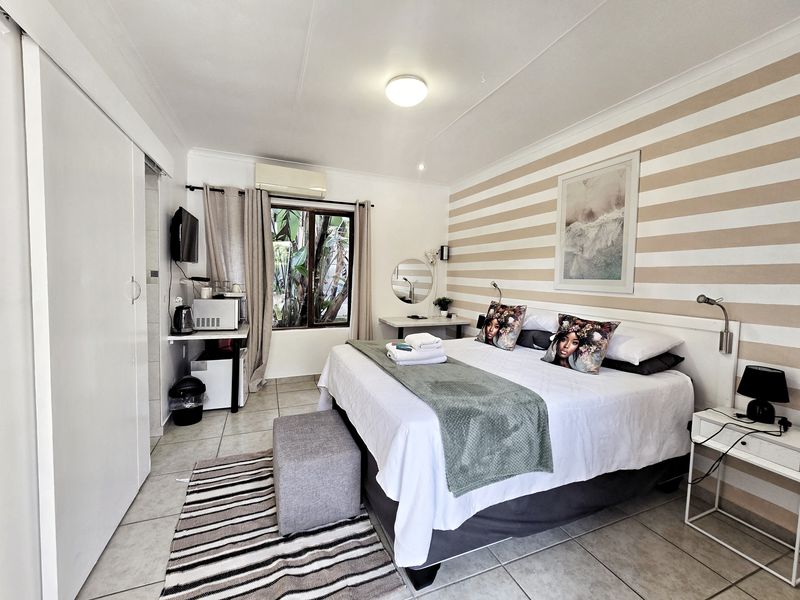 A bedroom featuring tiled flooring, a built-in wardrobe, and a split-system air conditioner, with a window providing natural light.