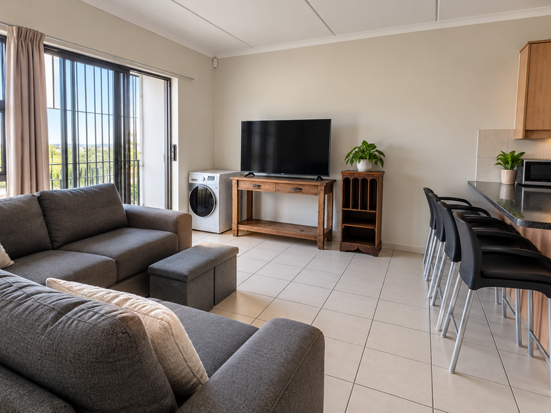 Open-plan living area featuring tiled floors, a modern kitchen with granite countertops, and direct access to a balcony through sliding doors.