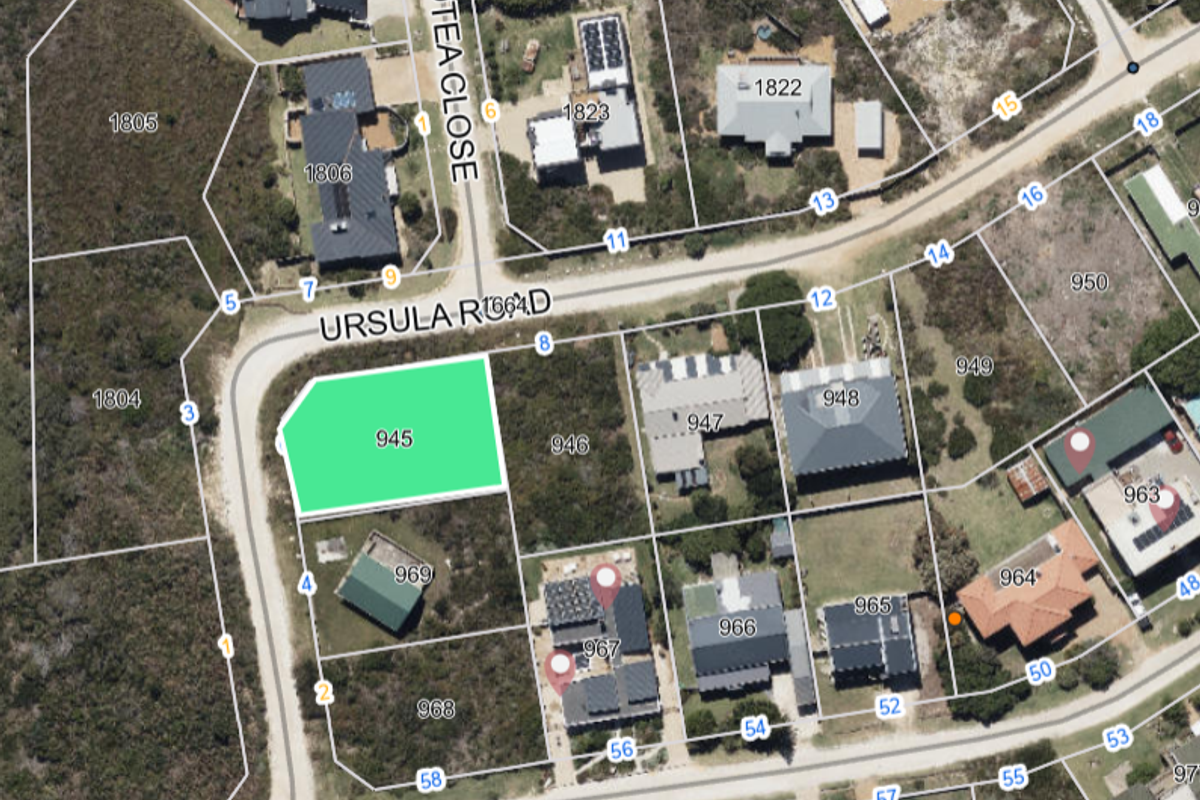 Aerial view of a vacant residential plot highlighted in green, situated within a developed neighborhood with clear cadastral boundary lines.