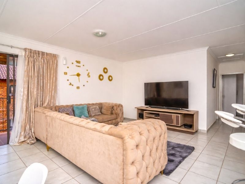 Open plan living area featuring tiled flooring and a sliding glass door providing access to the balcony.