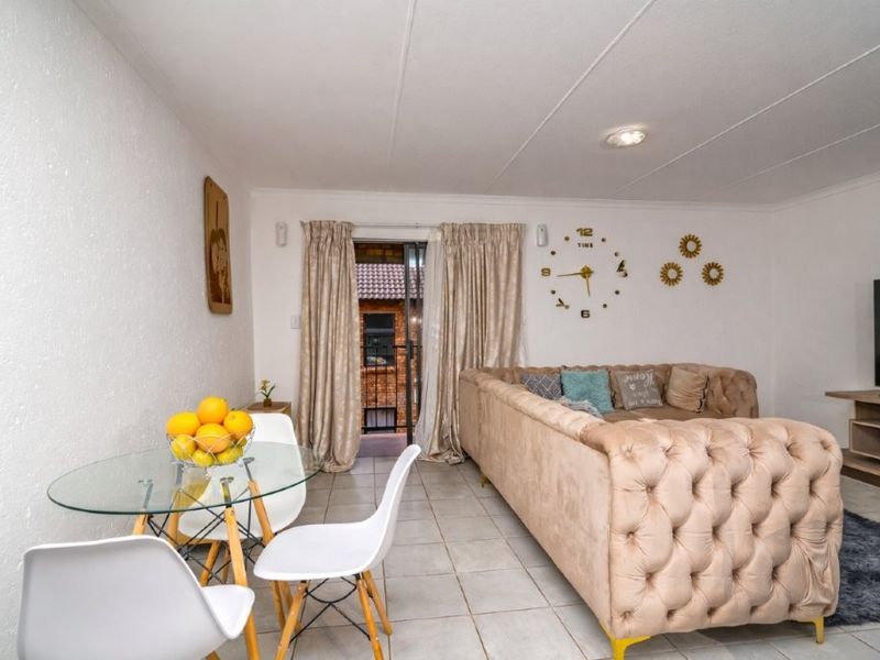 Open-plan living and dining area featuring tiled flooring and a sliding glass door providing access to the exterior.