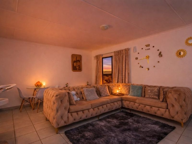 A cozy living room featuring tiled flooring and neutral walls, providing a comfortable and functional space for relaxation.