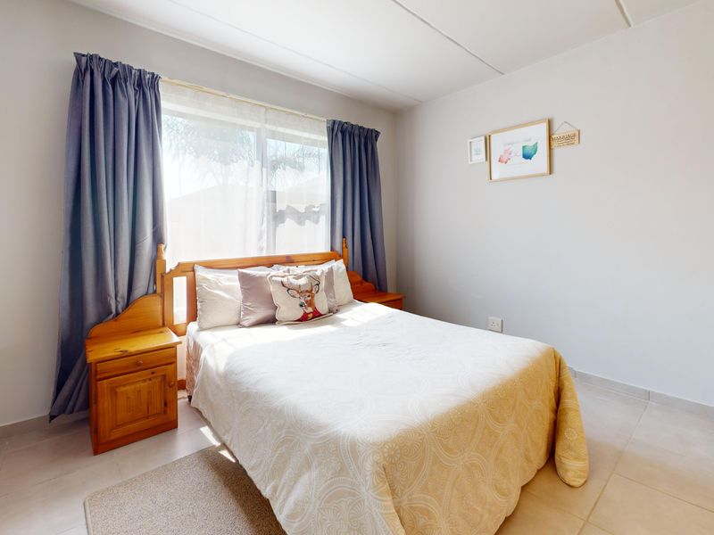A functional bedroom featuring tiled flooring and a built-in cupboard, offering a neutral space ready for personalization.