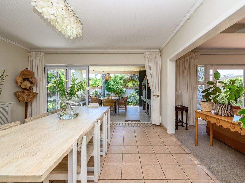 Spacious open-plan dining area featuring tiled floors and large sliding doors that provide seamless access to the covered outdoor patio.