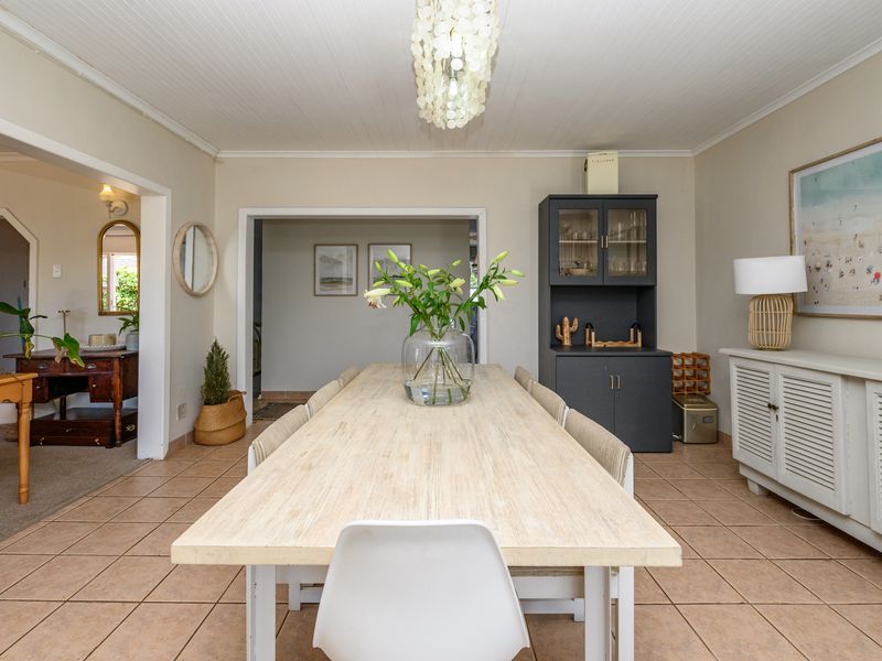 A bright dining room featuring tiled flooring, a beadboard ceiling, and built-in cabinetry, offering a functional and well-maintained space for family meals.