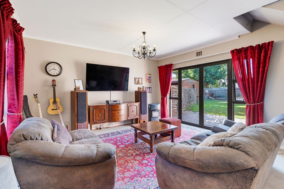 A comfortable living room featuring large sliding glass doors that provide direct access to the rear garden and patio area.