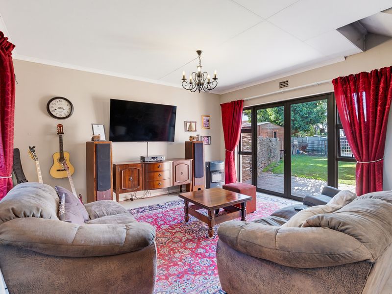A comfortable living room featuring large sliding glass doors that provide direct access to the rear garden and patio area.