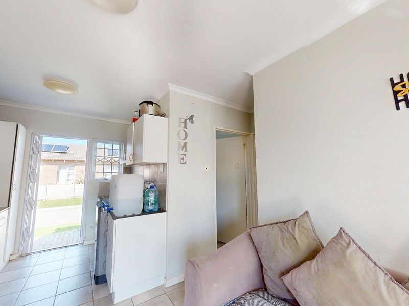Open plan living area featuring a compact kitchen with built-in cabinetry and direct access to the exterior through a sliding door.