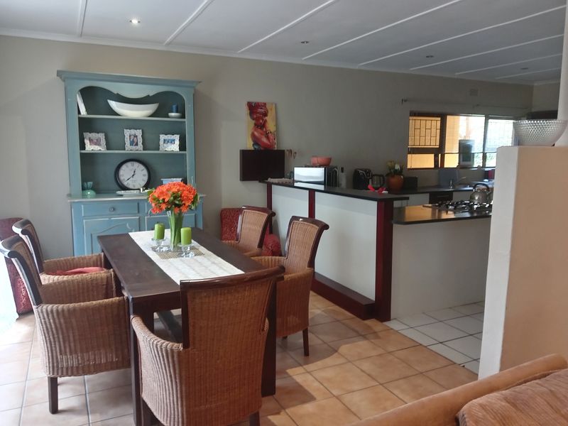 Open plan dining and kitchen area featuring tiled flooring, a breakfast bar, and built-in kitchen cabinetry with a gas hob.