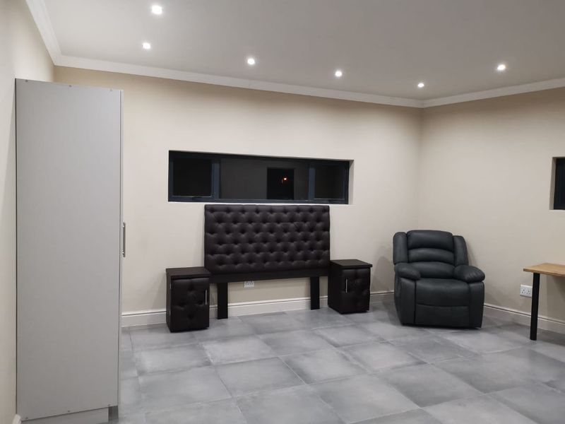 A bedroom featuring neutral walls, tiled flooring, recessed downlighting, and a horizontal window, providing a clean and modern foundation for personalization.