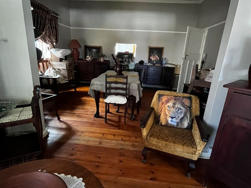 Open plan living and dining area featuring original timber flooring, picture rails, and coved ceilings, offering a classic foundation for renovation.