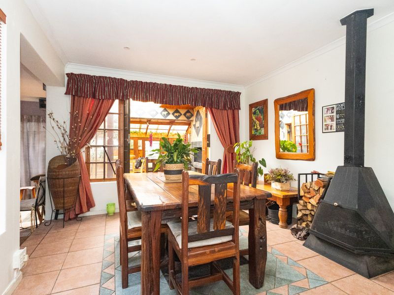 Dining room featuring tiled flooring and a prominent freestanding fireplace, with direct access to an adjoining patio area through sliding glass doors.