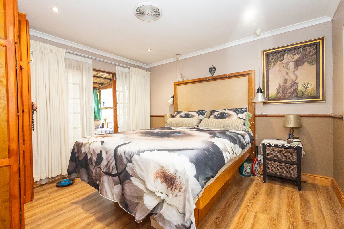 A bedroom featuring laminate flooring, recessed lighting, and sliding glass doors providing access to an outdoor area.
