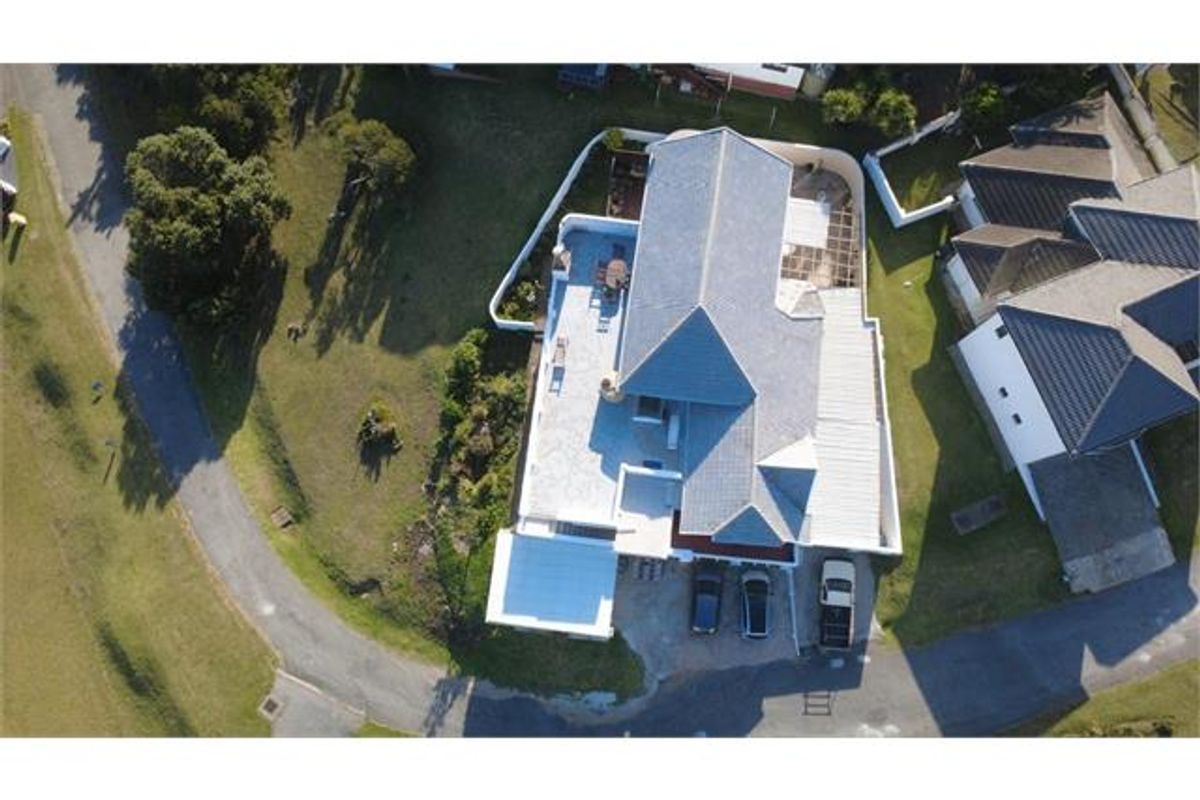 Aerial view of the property showing the roof structure, driveway, and surrounding garden area.