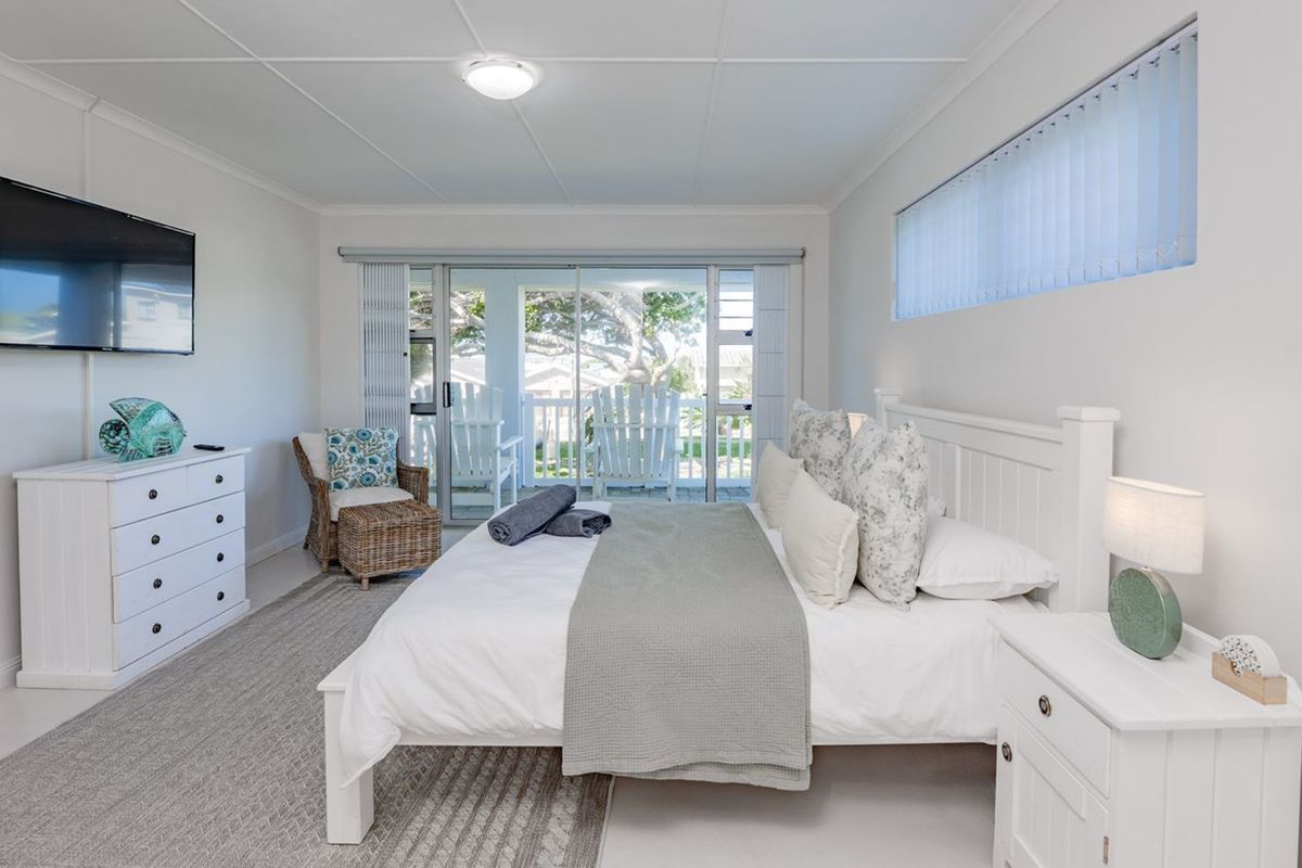 A bright and well-maintained bedroom featuring a sliding glass door that opens to an outdoor patio area.