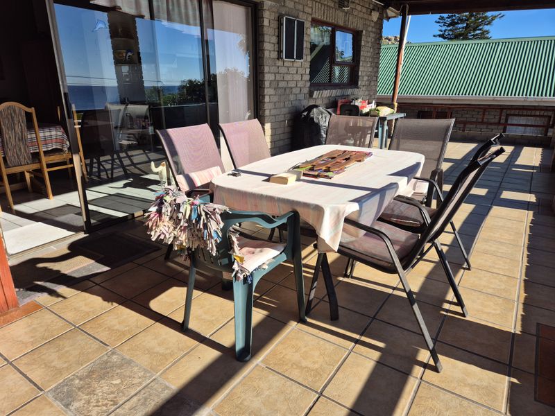 A covered outdoor patio area featuring tiled flooring and direct access to the interior through large sliding glass doors.