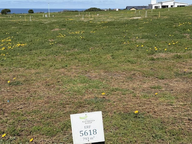A vacant residential erf measuring 793 square meters, featuring open land with distant ocean views in a developed estate setting.