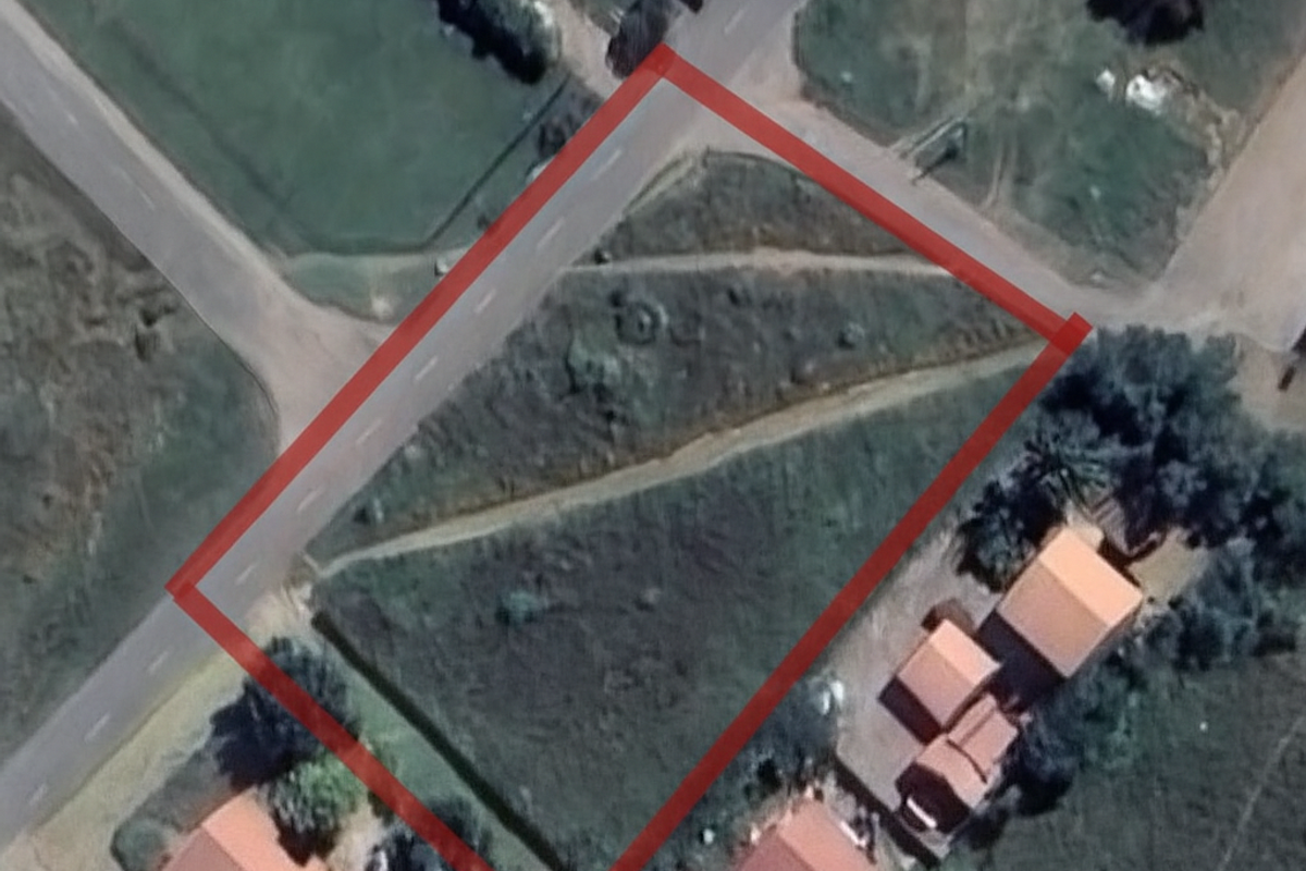 An aerial view of a vacant residential plot outlined in red, showing its position relative to surrounding roads and neighboring properties.