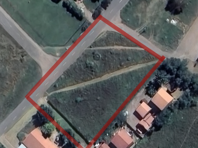 An aerial view of a vacant residential plot outlined in red, showing its position relative to surrounding roads and neighboring properties.