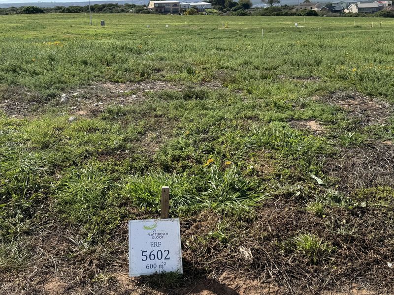 A vacant residential plot of 600 square meters, featuring natural vegetation and clear boundary markers, ready for development in a residential estate.