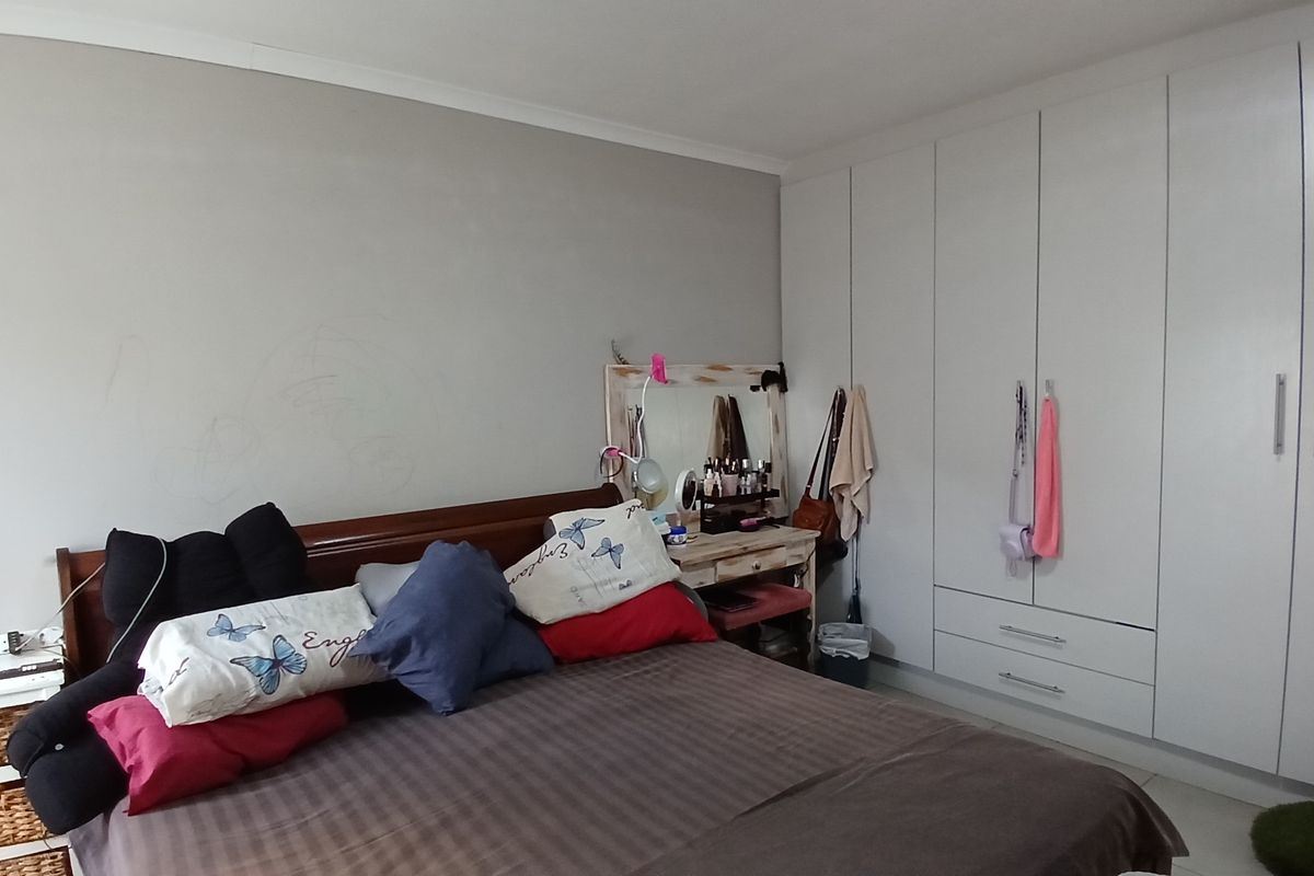 A bedroom featuring built-in cupboards with white cabinetry and coving detail.
