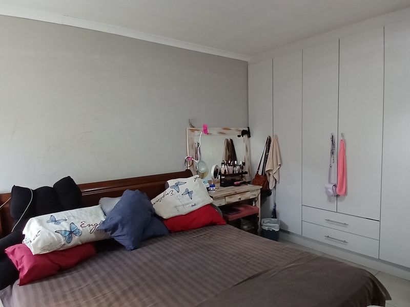 A bedroom featuring built-in cupboards with white cabinetry and coving detail.