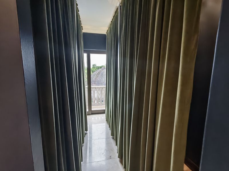 A narrow hallway featuring stone flooring leading to a sliding glass door with access to an outdoor balcony area.