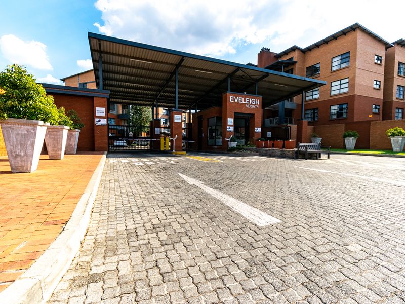 The main entrance to Eveleigh Heights apartment complex, featuring a secure gated access point, brick paving, and a covered entrance structure.