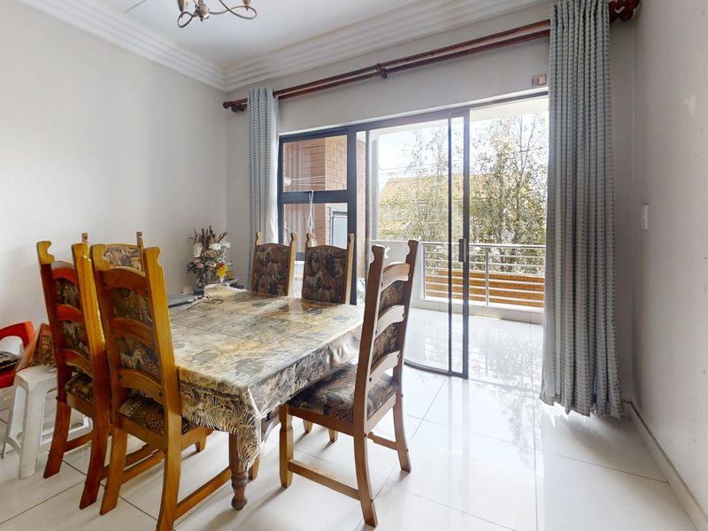 Dining area featuring tiled flooring and a large sliding glass door providing access to an outdoor balcony.