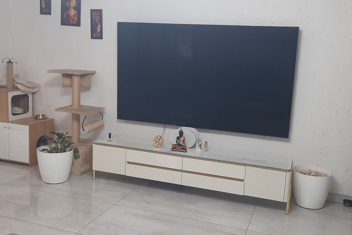 A living room area featuring large format porcelain floor tiles and dark venetian blinds, providing a neutral base for the space.